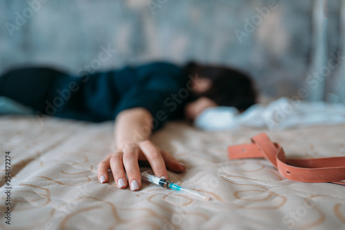 Female junkie sleeping in bed after dose photo