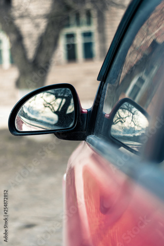 Side rear-view mirror of a red car