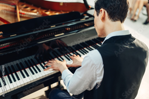 Pianist playing music on grand piano