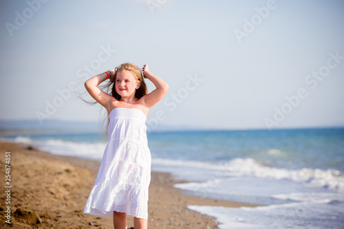 Bambina felice sulla riva del mare