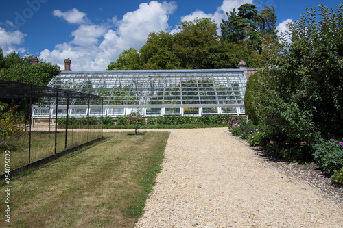 Large lean-to greenhouse in an English country garden
