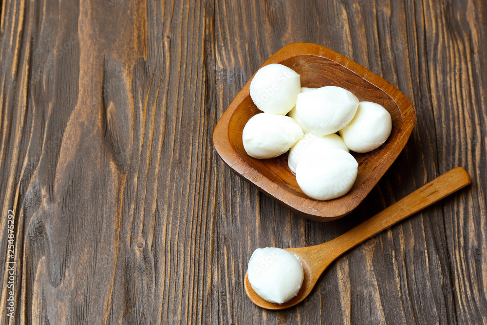 Mozzarella cheese in a wooden bowl on the table Mozzarella cheese in a wooden bowl on the table