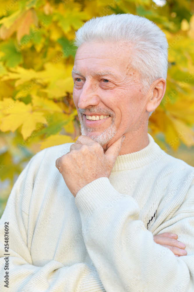 Portrait of happy elderly man posing in autumn park Portrait of happy elderly man posing in autumn park