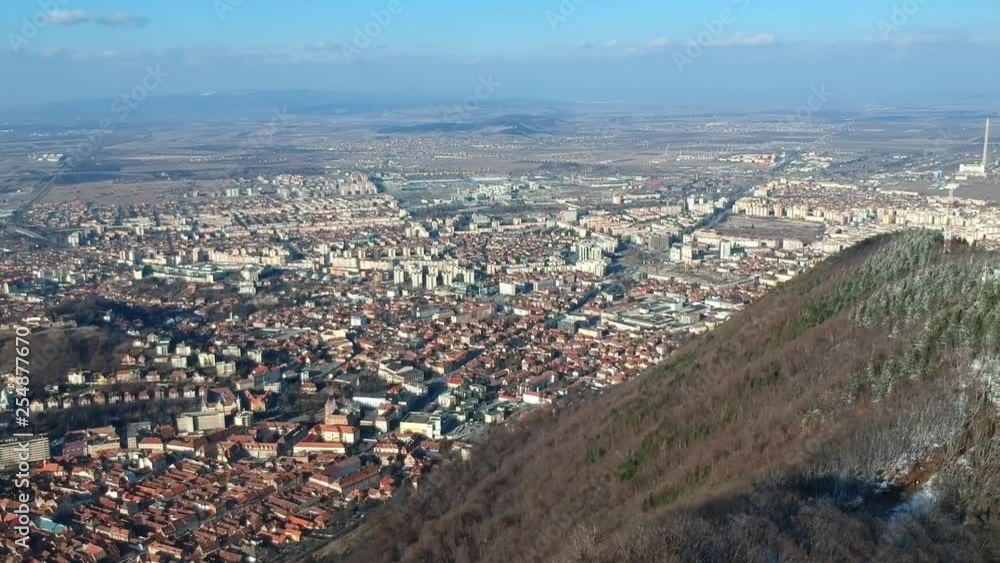 Aerial panoramic view of Brasov from the Tâmpa mountain showing the old and the new part of the city , with the main square and Black Church and typical architecture of houses in Transylvania , Roman Aerial panoramic view of Brasov from the Tâmpa mountain showing the old and the new part of the city , with the main square and Black Church and typical architecture of houses in Transylvania , Roman