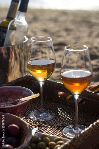 Puesta de sol en la playa con copa de vino