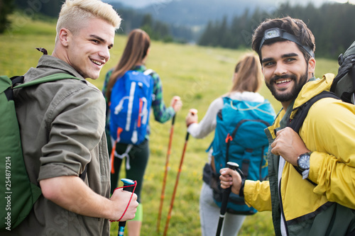Adventure, travel, tourism, hike and people concept - group of smiling friends with backpacks and map outdoors