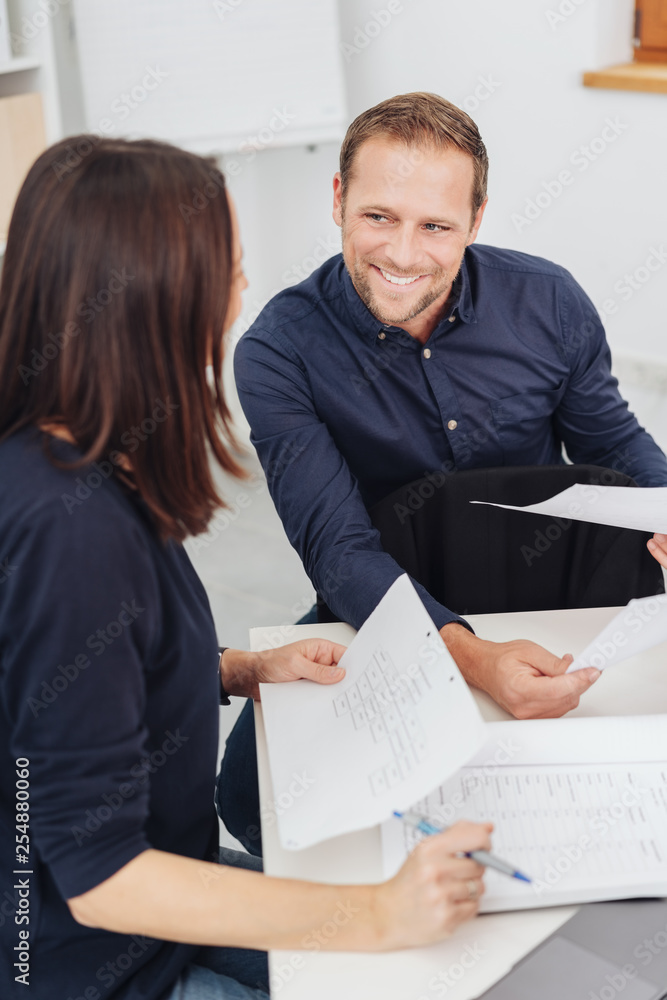 Young businessman discussing notes with colleague Young businessman discussing notes with colleague