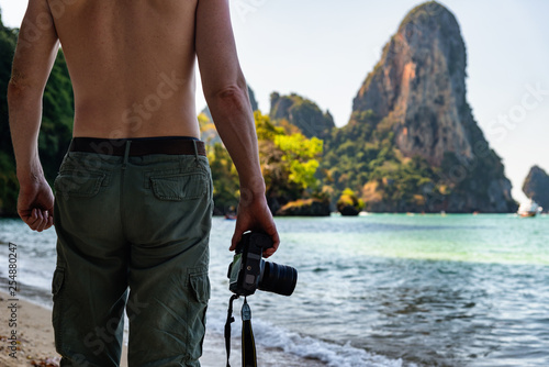Photographer holding camera on the beach in Thailand
