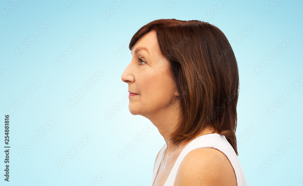 Fototapeta premium beauty, rhinoplasty and old people concept - profile of senior woman over blue background