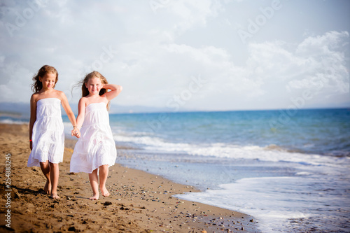 belle bambine a camminare sulla riva del mare