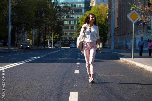 Young beautiful brunette woman walking on the street