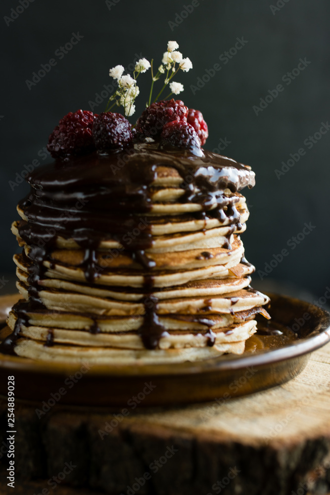 Vegan pancakes with chocolate sauce and  raspberries