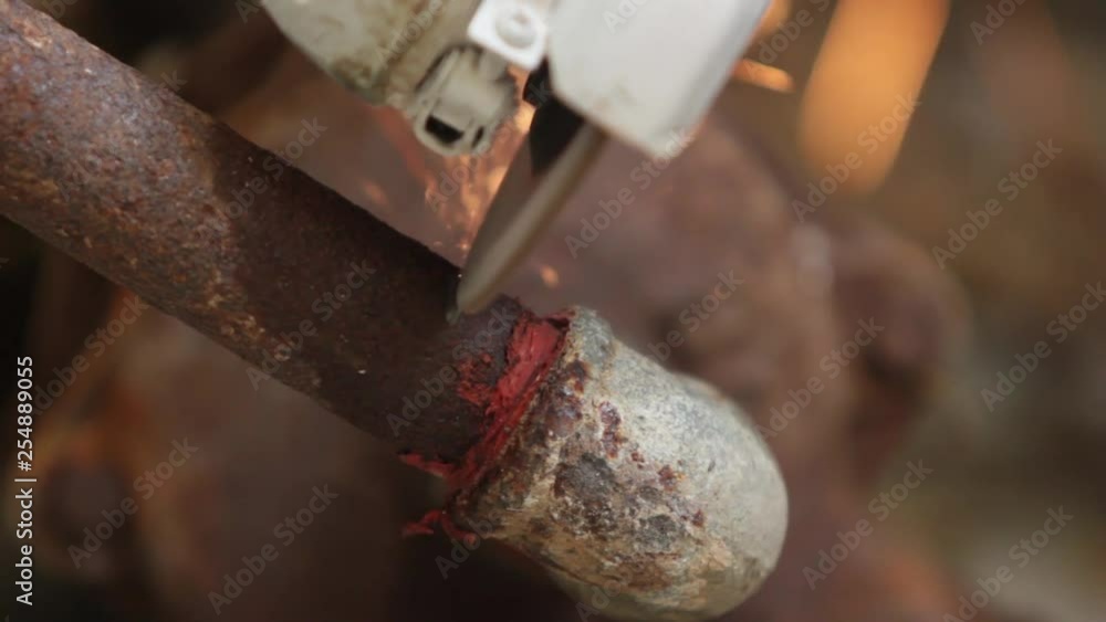 Frontal view of a portable grinding machine, rusty metal pipe cutting, trim, bright sparks Frontal view of a portable grinding machine, rusty metal pipe cutting, trim, bright sparks