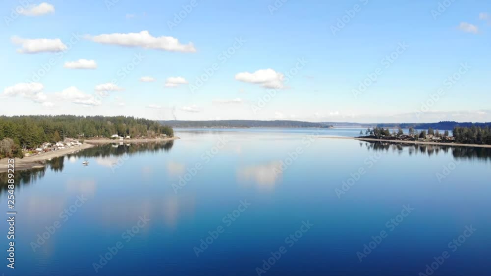 Drone flying up over Puget Sound in Washington state. Views of the ocean and mountains and trees. Beautiful sunny day in Washington. Drone flying up over Puget Sound in Washington state. Views of the ocean and mountains and trees. Beautiful sunny day in Washington.