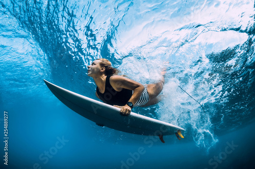 Photography Surfer woman dive underwater. Surfgirl dive under big wave