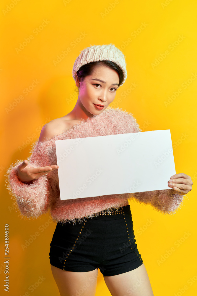 Your text here. Pretty young excited woman holding empty blank board. Colorful studio portrait with yellow background. Your text here. Pretty young excited woman holding empty blank board. Colorful studio portrait with yellow background.