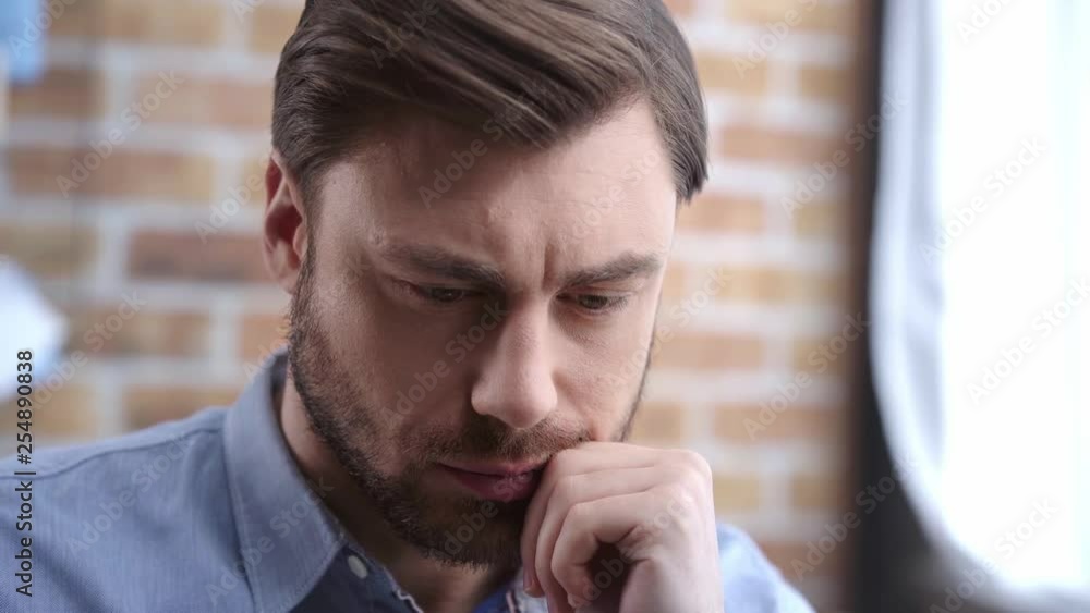 Businessman in shirt thinking, touching face with hand and thoughtfully looking away Businessman in shirt thinking, touching face with hand and thoughtfully looking away