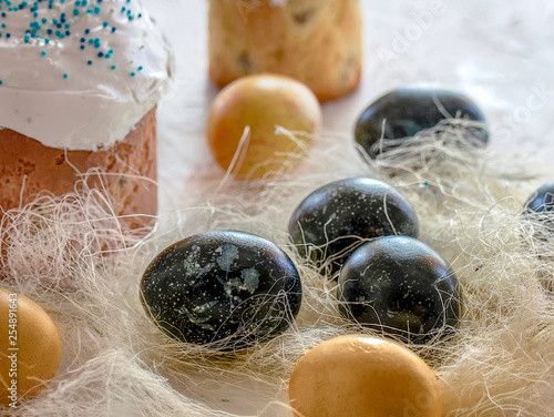 Festive Easter cakes on the wooden white background surrounded by painted eggs. photo