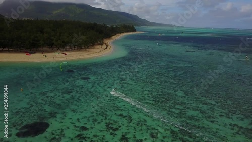 Kitesurfing towards beautiful beach on paradise island mautitius. Filmed with drone in 4K on a sunny day with christal clear blue water