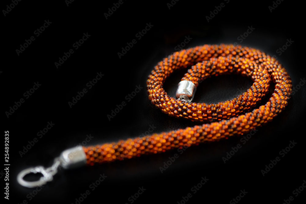 Amber color necklace on a dark background close up Amber color necklace on a dark background close up