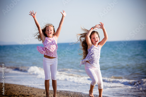 Belle bambine saltando sulla spiaggia photo