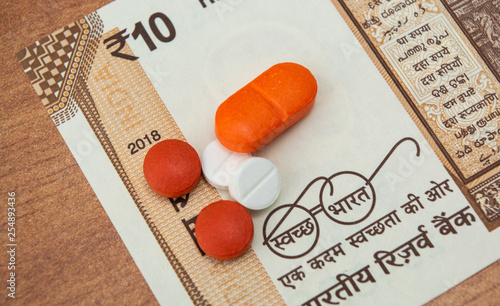 Concept of the affordable medicine in India due to generic drugs on Indian currency notes as background. photo