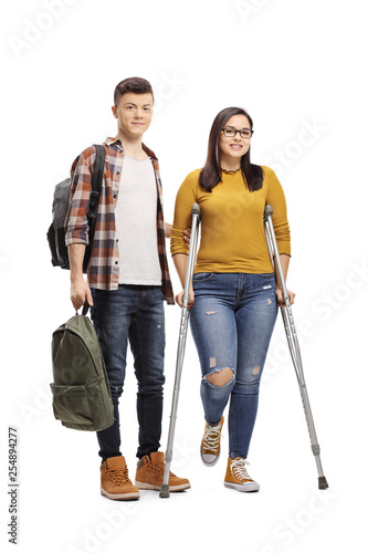 Male student helping a female student walking with crutches