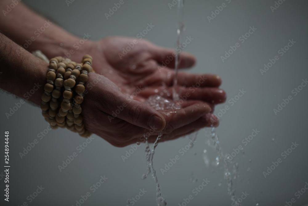 Muslim man washes his hands before prayer ritual cleansing.