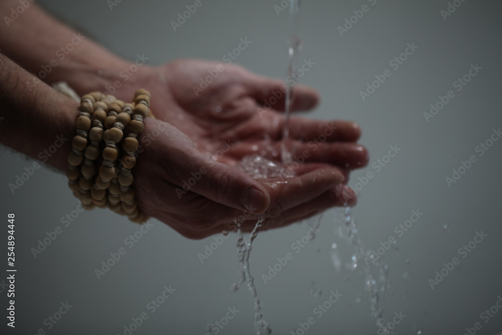 Fototapeta premium Muslim man washes his hands before prayer ritual cleansing.