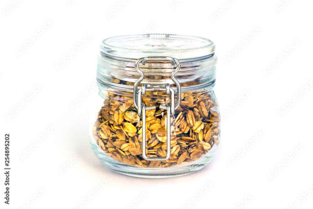 Oatmeal granola in a glass jar isolated on white Oatmeal granola in a glass jar isolated on white