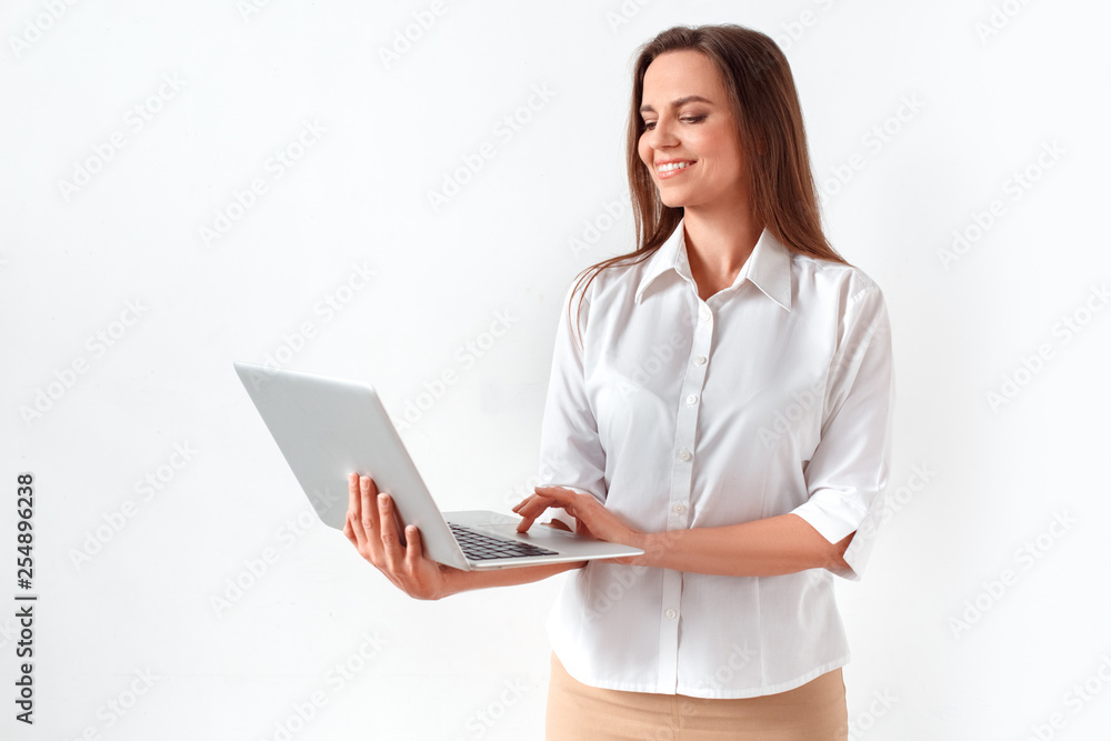 Modern technology. Woman standing isolated on white browsing internet on laptop joyful Modern technology. Woman standing isolated on white browsing internet on laptop joyful