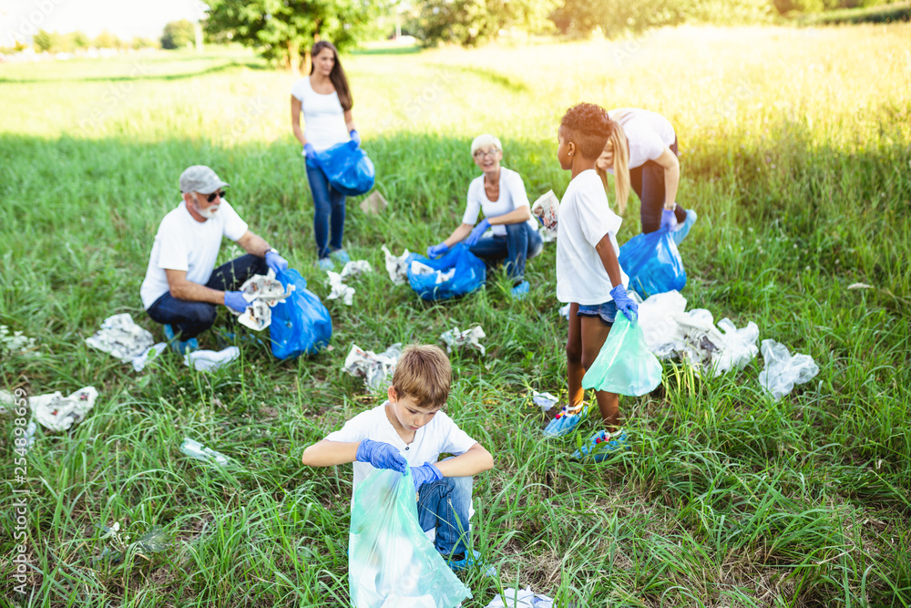 Fototapeta premium Volunteers with garbage bags cleaning up garbage outdoors - ecology concept.