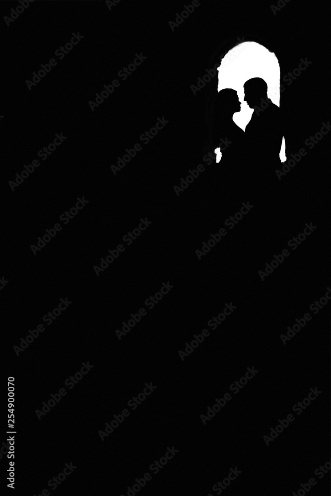 Love of man and woman depicted in couple silhouettes holding hands and looking on each other. Young lovers postures isolated on white background. black and white silhouette of two people