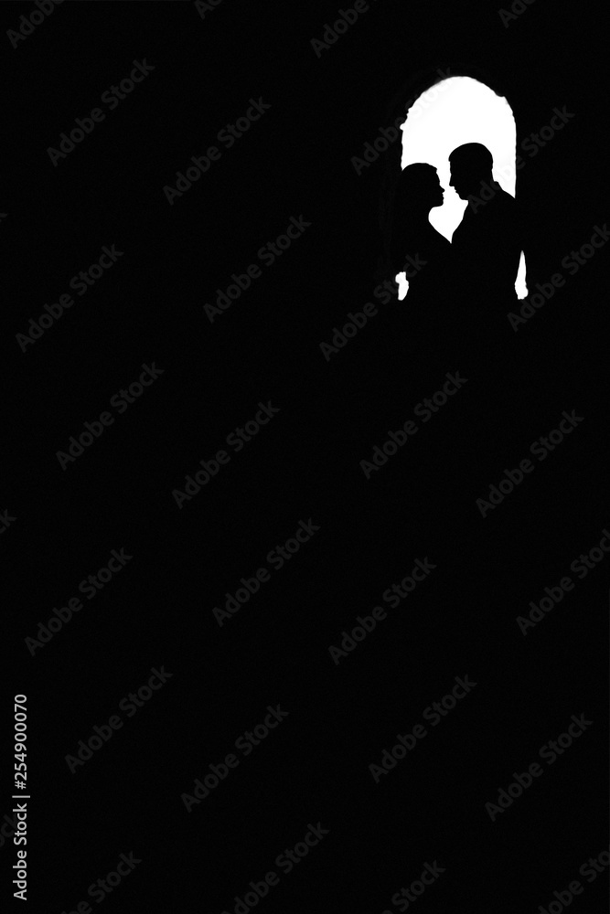 Love of man and woman depicted in couple silhouettes holding hands and looking on each other. Young lovers postures isolated on white background. black and white silhouette of two people Love of man and woman depicted in couple silhouettes holding hands and looking on each other. Young lovers postures isolated on white background. black and white silhouette of two people