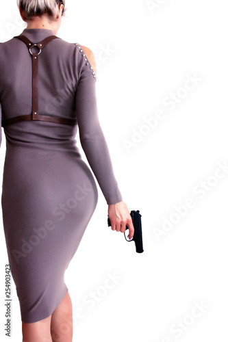 Beautiful woman in a dress holding a gun in her hand.