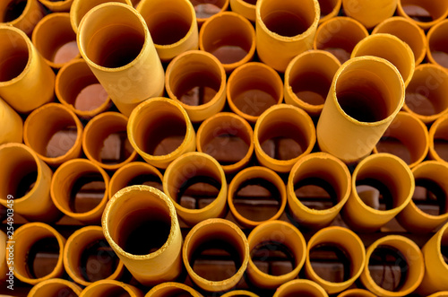 Front view of abstract art structure created by stacking yellow PVC pipes together at an exhibition