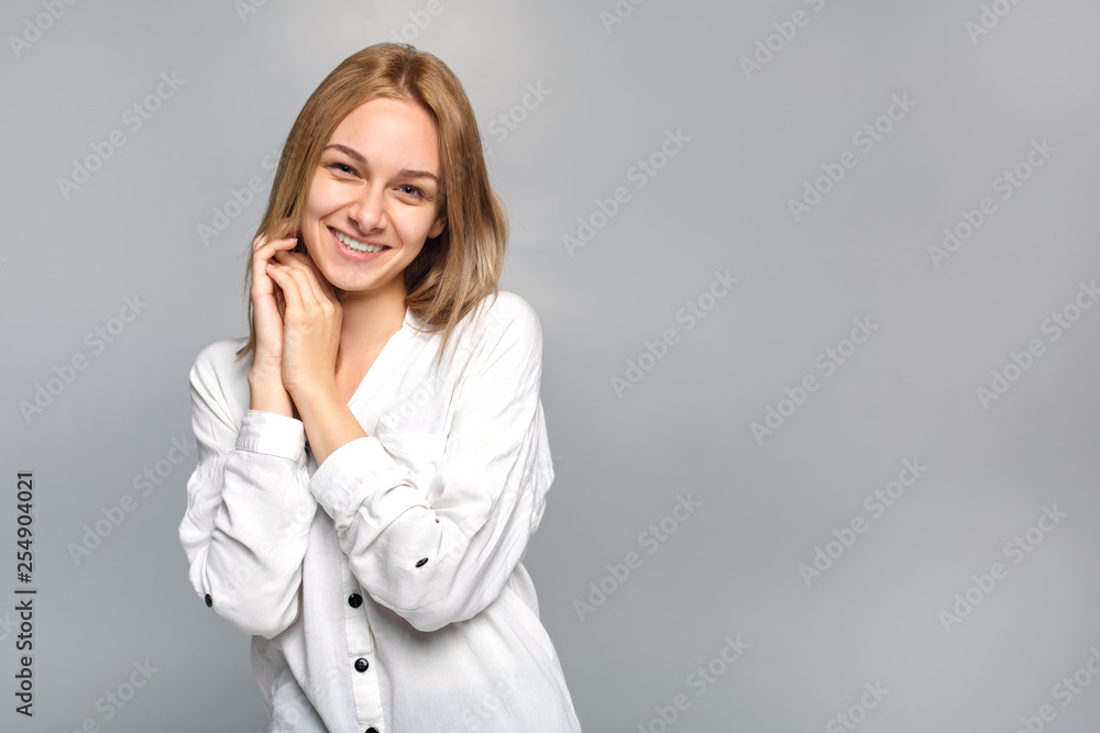 Young woman standing isolated on grey smiling cute Young woman standing isolated on grey smiling cute