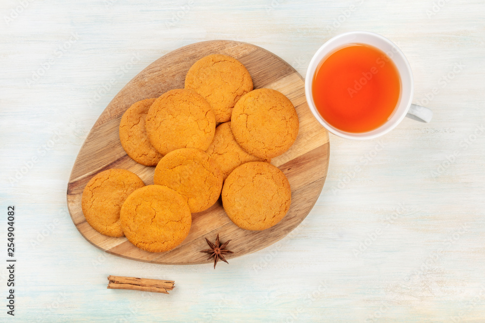 Gingersnaps, shot from above with a cinnamon stick, an anise star, a cup of tea, and a place for text Gingersnaps, shot from above with a cinnamon stick, an anise star, a cup of tea, and a place for text