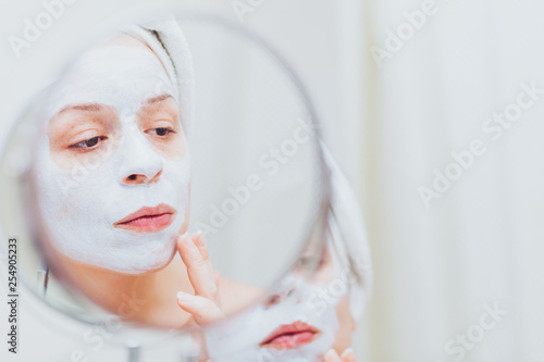 Young woman putting a mask on her face