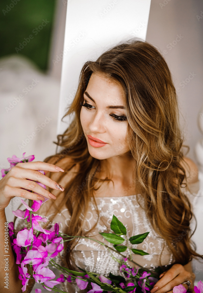 Portrait of a stunning girl with purple flowers in her hands Portrait of a stunning girl with purple flowers in her hands