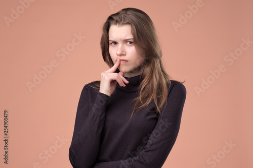 Thinking young woman trying to make a right decision.