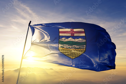 Alberta province of Canada flag waving on the top sunrise mist fog photo