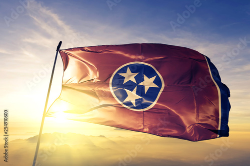 Tennessee state of United States flag waving on the top sunrise mist fog photo