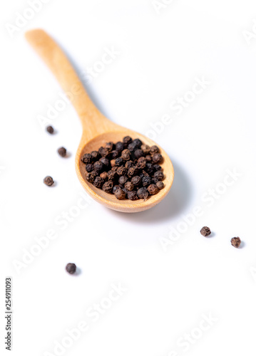 black pepper in spoon on white background