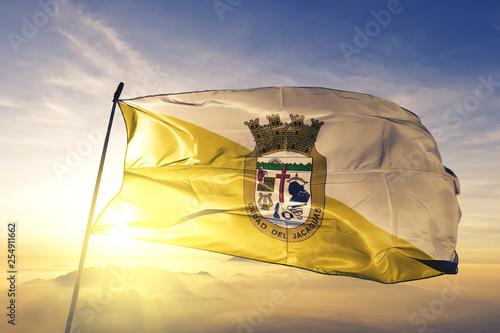 Juana Diaz municipality of Puerto Rico flag waving on the top sunrise mist fog