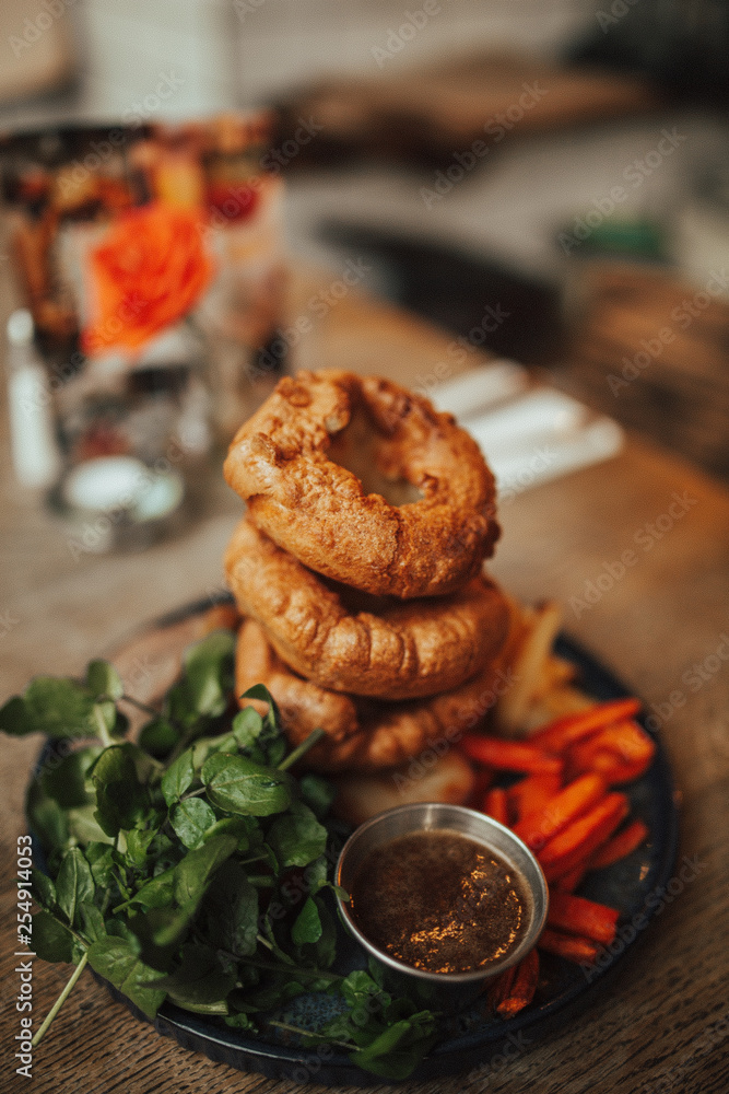 A close up shot of traditional British food, Sunday roast. Yorkshire pudding with roasted meat and vegetables. Concept of family lunch, celebration and traditional cuisine.