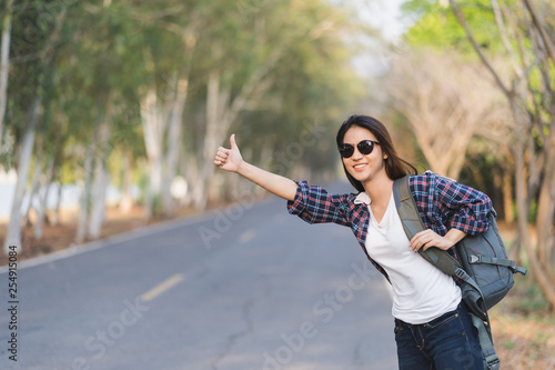 Bilde på lerret Portrait of a young attractive happy Asian woman traveler backpacker background