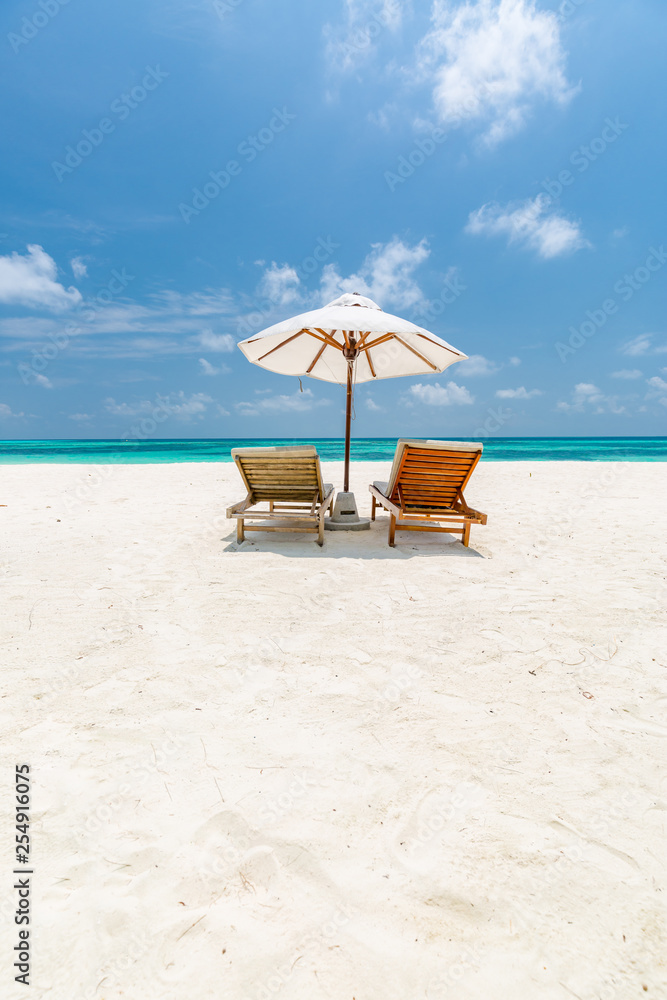 Beautiful Maldives island beach landscape. Luxury resort with chairs and umbrella for summer vacation and holiday background. Exotic tropical beach concept