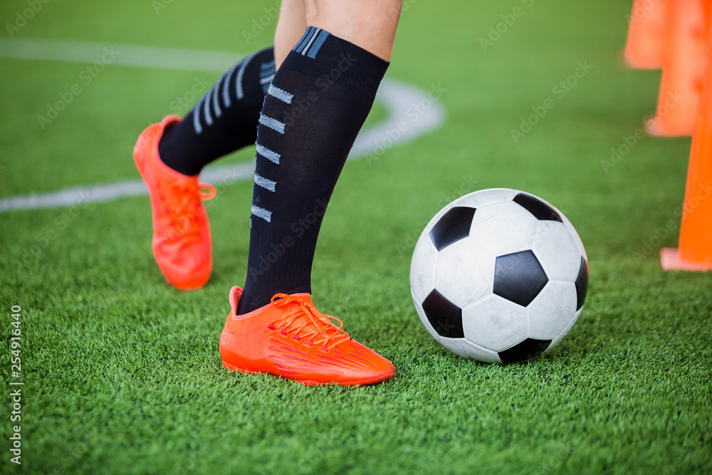 Fototapeta premium soccer player jogging with trap and control football between cone markers