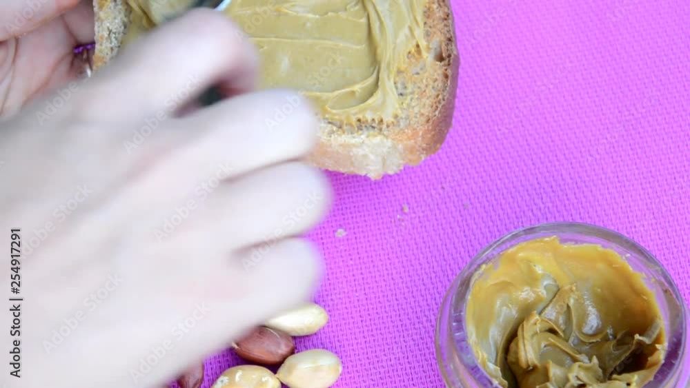 Vídeo do Stock girl making a sandwich. spooning peanut butter out of a